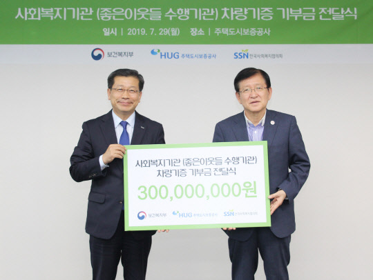 이재광 HUG 사장(왼쪽)과 서상목 한국사회복지협의회장(오른쪽)이 사회복지기관 차량 기증사업 기부금 전달식을 갖고 기념 촬영을 하고 있다. <HUG 제공>